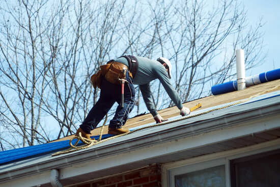 roofer installing new roof shingles